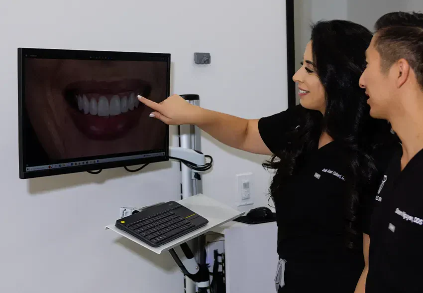 A dentist walking a patient through their smile on screen