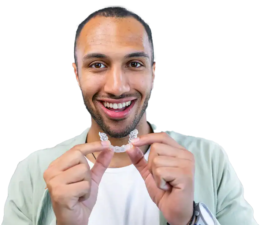 An adult patient holding an Invisalign aligner at The Smile Spa